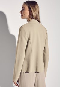 Beige textuur blazer met een slim fit, voorzien van een kleine kraag en lange mouwen. De achterkant van de zoom is licht gebogen voor een Tailored look.