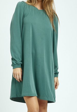 Langärmliges, locker sitzendes, grünes Kleid aus weichem Material. Verfügt über einen runden Ausschnitt und geraffte Ärmel, die oberhalb des Knies enden.