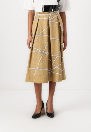 Jupe midi plissée marron avec imprimé ruban blanc portant la mention « Elisabetta Franchi », associée à des chaussures à talons hauts noires, montrée de la taille vers le bas.