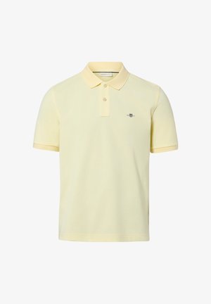 Hellgelbes Polohemd mit kurzer Ärmel, zwei Knöpfen und einem kleinen bestickten Logo auf der linken Brustseite.