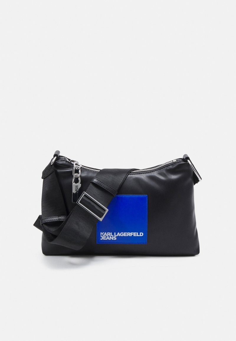 Black synthetic shoulder bag with a zip closure, a blue patch featuring the "KARL LAGERFELD JEANS" logo, and an adjustable strap.