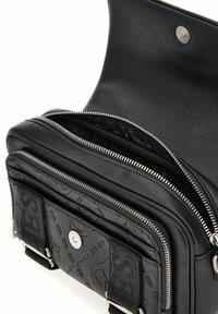 Borsa in pelle nera con più scomparti con cerniera, una tasca frontale con chiusura a scatto e dettagli con motivo testurizzato. Parti in metallo argentato.