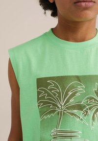 Zelen majica brez rokavov iz bombaža s grafiko palme v beli barvi na temno zeleni podlagi, s krojačkim ovratnikom in mehkobo.