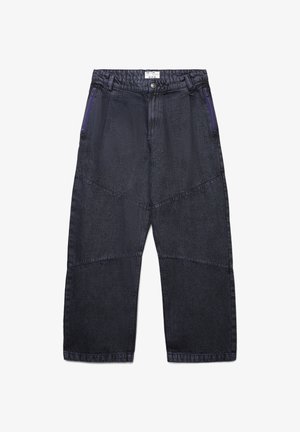 Pantaloni a gamba larga in denim scuro con tasche diagonali dotate di cerniere viola, un finish testurizzato e dettagli di cucitura orizzontali distintivi.
