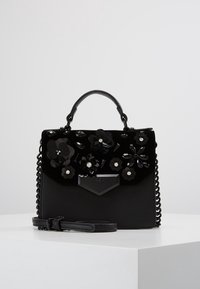 Czarna torebka z aksamitu z kwiatowymi zdobieniami, łańcuszkową rączką i skórzanymi akcentami. Charakteryzuje się usztywnionym kształtem i odpinanym paskiem.