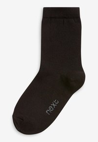 Chaussette noire côtelée avec un orteil arrondi. Le tissu semble lisse et extensible, avec un petit logo 'next' en gris clair sur le côté.