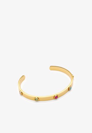 Pulsera de brazalete abierta de oro con cuatro pequeñas piedras redondas en rosa, verde y azul espaciadas uniformemente a lo largo de la banda sobre un fondo blanco.