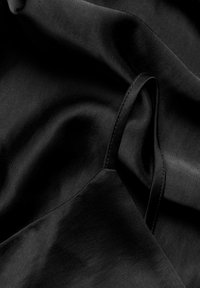 Schwarzer Satin-Stoff mit glatter Textur, elegant fallend und mit subtiler Ausstrahlung. Die Kanten sind sauber verarbeitet und zeigen qualitativ hochwertige Handwerkskunst.