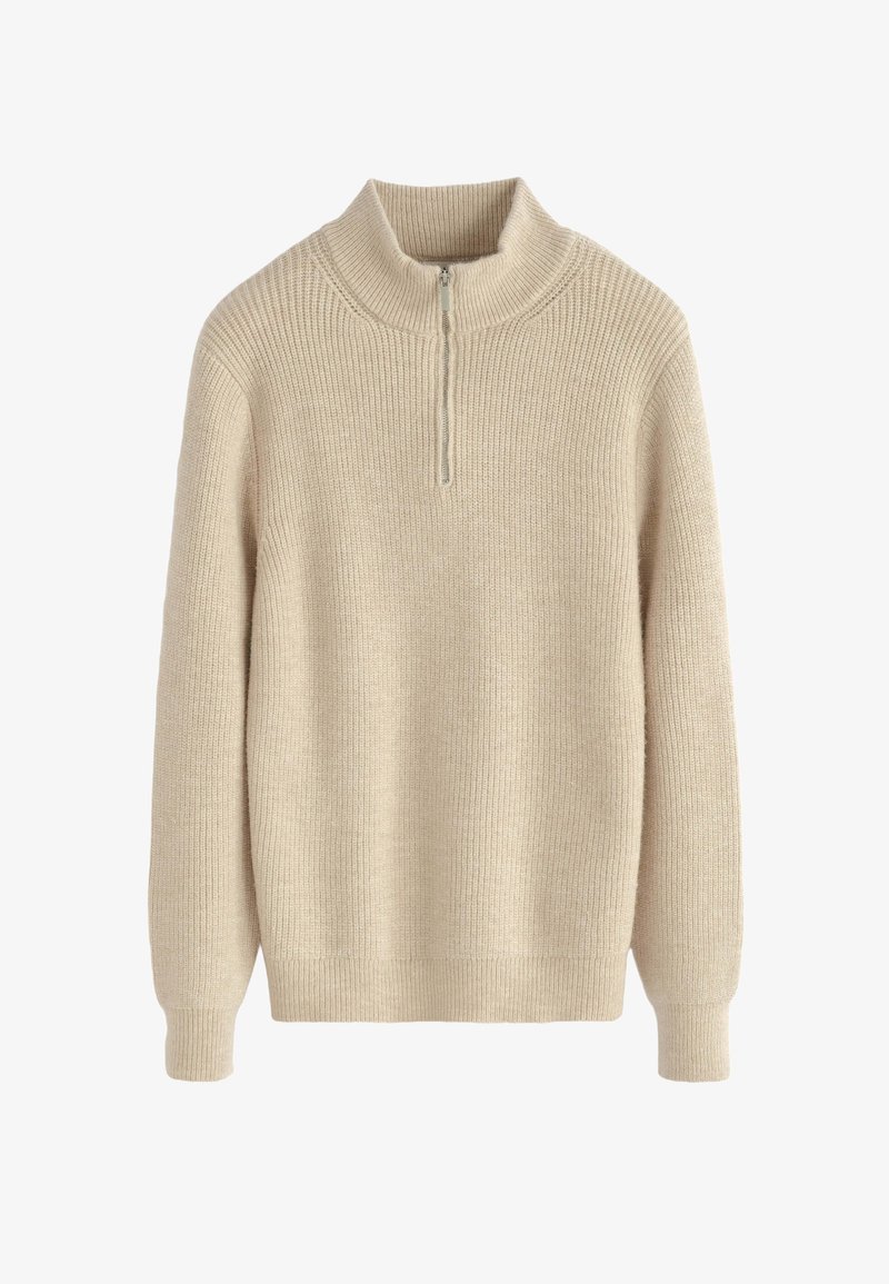 Pull en tricot beige à côtes avec des manches longues et une courte fermeture éclair au col montant.