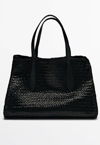 Sac fourre-tout noir tissé avec des poignées en cuir lisse, de forme rectangulaire, extérieur texturé, et sans matériel ou accents visibles.