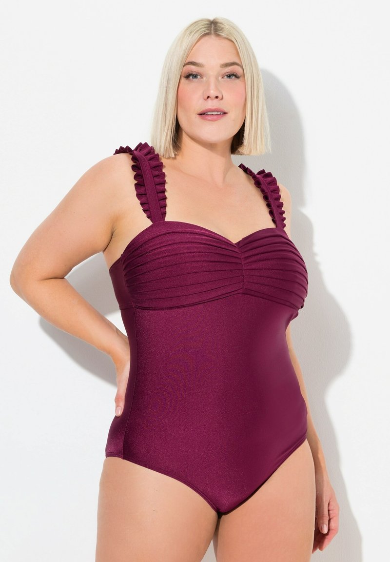 Maillot de bain une pièce bordeaux avec texture côtelée et bretelles volantes, offrant une silhouette ajustée et une finition en tissu lisse.