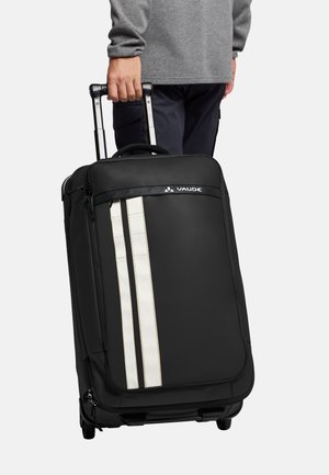 Schwarze Reisetasche mit weißen vertikalen Streifen, strapazierfähigem Stoff, ausziehbarem Griff, Seitentasche mit Reißverschluss und vier Rollen für einfache Mobilität.