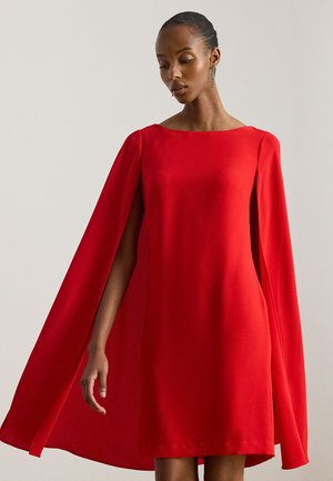 Abito rosso con scollo quadrato e maniche a mantella eleganti. La texture liscia del tessuto crea una silhouette slanciata.