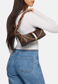 Brown patterned handbag with a gold chain strap and a black and white accent. The bag has a textured finish and a curved shape.