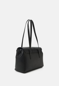 Crna kožna torba s oblikom koji drži strukturu, ravnim vrhom, dva izdužena ručka i teksturiranom površinom. Ima bočnu džep.