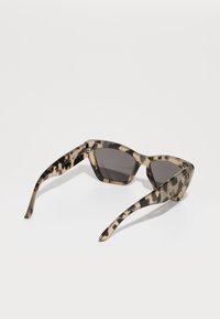 Tortoiseshell sunglasses with angular frames, dark lenses, and decorative hardware on the hinges. Glossy finish with contrasting patterns.