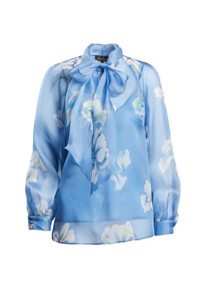 Jasnoniebieska bluzka z przezroczystego materiału z kwiatowym wzorem, dekolt z kokardą, długie bufiaste rękawy i marszczenia przy mankietach.