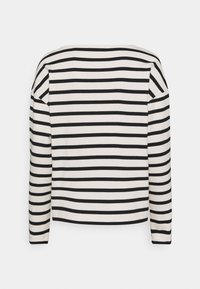 Lange mouw top in crème met horizontale zwarte strepen. Relaxte pasvorm, bootnek en een zachte textuur. Geen sluitingen of versieringen.