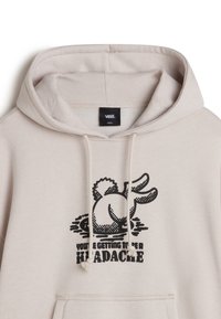 Beige hoodie featuring a graphic of a rabbit with the text "YOU'RE GETTING TO BE A HEADACHE" in black. Soft fabric with drawstrings.
