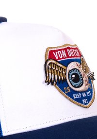 Casquette blanche avec une visière bleue, ornée d'un patch brodé représentant un œil, des ailes, et le texte "VON DUTCH" et "GARDER UN ŒIL OUVERT."