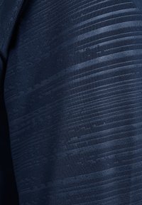 Tissu bleu foncé avec des rayures horizontales texturées créant un motif subtil de nuances variées et de lignes en relief.