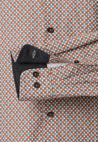 Herrenhemd mit einem geometrischen Muster aus orangefarbenen Punkten und schwarzen Akzenten auf einem weißen Hintergrund. Schwarze Knöpfe und ein denimähnliches Kragen-Design.