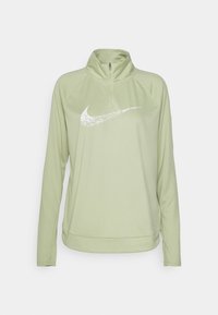 Ljust grön Nike zip-up hoodie med hög krage, långa ärmar och en stor vit logotyp framtill. Har ett mjukt, elastiskt material.