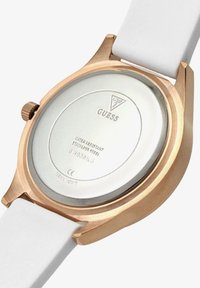 Roosa kuldne kell, mille taga on valge rihm, graveeritud Guess'i logo, veekindel roostevabast terasest, mudelinumber ja küljes kroon.