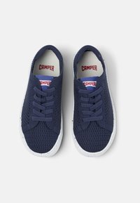 Sneakers in rete blu navy con suole e lacci bianchi in gomma. Presentano una superficie superiore testurizzata e il logo CAMPER sulla soletta.