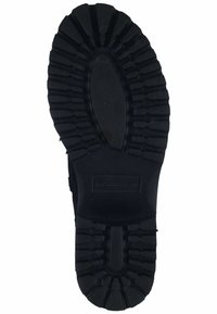 Suela de zapato de goma negra con un patrón texturizado, que presenta crestas y surcos para mayor agarre. Forma ovalada y plana con una sección media reforzada.