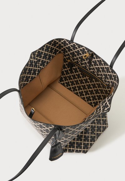 Sac cabas ouvert à motifs noirs et beiges avec intérieur beige, poche zippée noire, fermoir doré et anses en cuir noir.