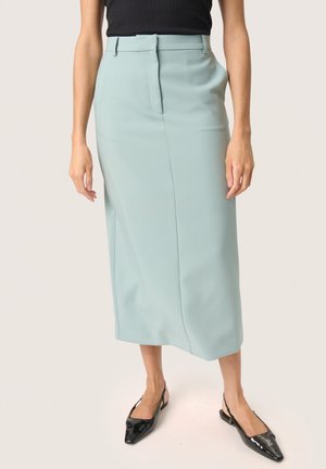 Lys teal blyantskørt med en glat tekstur, mellemlangt design og sidelommer, parret med sorte spidse slingback sko.