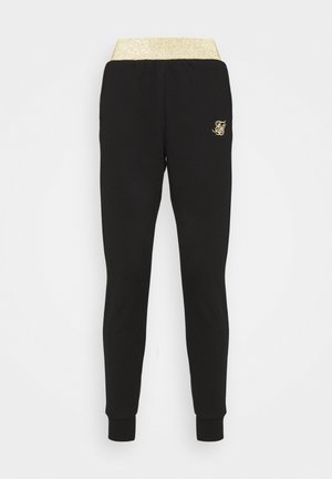 Joggers noirs ajustés avec taille élastique dorée et petit logo doré sur la cuisse gauche sur fond blanc.