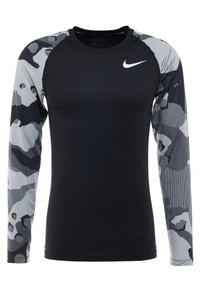 Czarna sportowa koszulka z długim rękawem z szarymi rękawami w kamuflażu. Wykonana z tkaniny odprowadzającej wilgoć. Posiada małe białe logo na klatce piersiowej.