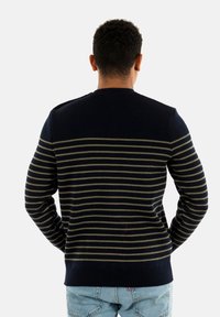 Maglione lavorato a maglia navy con strisce verdi, orlo a costine e scollatura rotonda. Presenta una texture liscia e una vestibilità su misura.