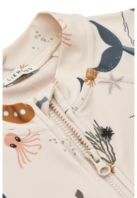 Svetlo roza majica za plavanje z vzorci v morskem slogu, ki vključujejo hobotnice in morsko travo. Ima sprednjo zadrgo v ujemajoči se svetli barvi.