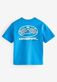 Modra bombažna majica z grafiko križanih karirastih dirkaških zastav in besedilom "82 ORIGINAL Racing" v beli in črni barvi.