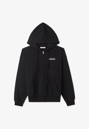 Felpa nera con zip, cappuccio con coulisse, polsini a coste e tasca a marsupio. Presenta la scritta bianca "CERCASI" sul petto a sinistra.