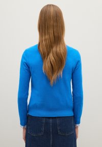 Blauwe gebreide trui met lange mouwen en ribgebreide manchetten, van achteren getoond. Soepele textuur, aansluitend ontwerp en een ronde halslijn.
