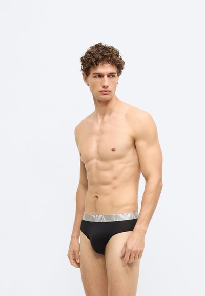 Fekete pamut alsónadrág szürke elasztikus derékpánttal, logóval díszítve. Sima textúrájú és testre simuló kialakítás a kényelem és a támogatás érdekében.