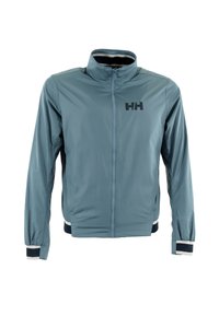 Giacca leggera blu con colletto alto, zip frontale a tutta lunghezza e logo nero. Presenta polsini elasticizzati e dettagli a righe sull'orlo.