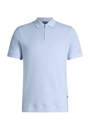 Polo azzurro chiaro a maniche corte con coste verticali strutturate e cerniera frontale sotto il colletto.