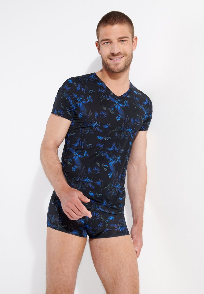 Black V-neck shirt and matching shorts with a blue floral pattern, made of soft fabric; fitted design emphasizing the body shape.
