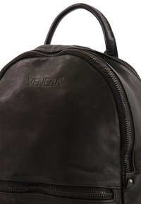 Zwarte leren rugzak met een afgeronde vorm, een bovenhandvat, een opvallende rits en een geperst "VENEZIA" logo aan de voorkant.