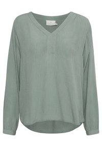 Blouse à manches longues et col en V, dans un vert muted, dotée d'un tissu texturé, d'une coupe ample et d'un ourlet arrondi avec des poignets boutonnés.