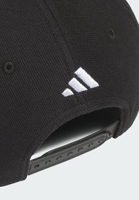 Černá baseballová kšiltovka vyrobená z texturované tkaniny, s bílou vyšívanou logem se třemi pruhy na boku a nastavovacími popruhy na zadní straně.