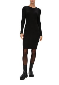Schwarz gerippter Strickkleid mit langen Ärmeln, taillierter Passform, rundem Ausschnitt und knielangem Schnitt, kombiniert mit klobigen schwarzen Stiefeln. 