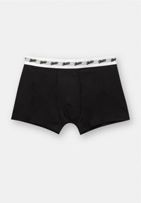 Fekete boxeralsó, puha anyagból, fehér derékrésszel, amelyen a márka logója ismétlődik. Klasszikus téglalap alak, minimális dizájn.