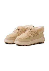 Beige ankelstøvler med blødt shearling-overdel, ruskindsdetaljer og runde snørebånd. Tekstureret gummisål med mønstret slidbane for bedre greb.
