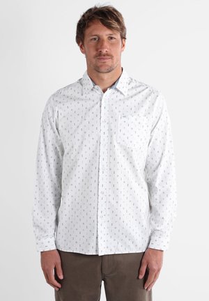 Chemise blanche à manches longues avec un motif de diamant subtil, fermée par des boutons à l'avant et une poche poitrine. Fabriquée en tissu léger ; coupe décontractée.